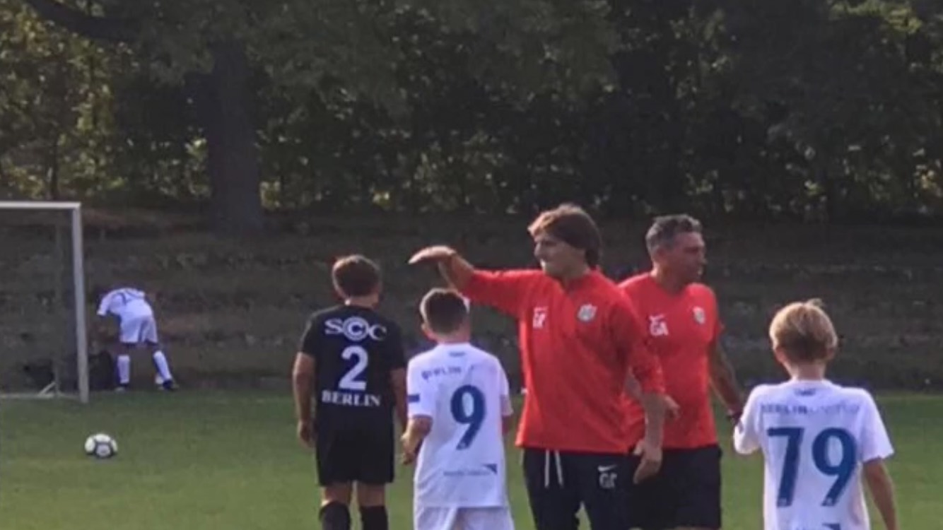 Coach leading a youth football session in Berlin