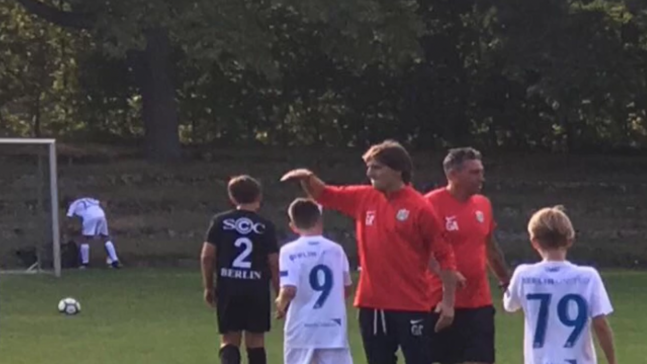 Entrenador dirigiendo una sesión de fútbol juvenil en Berlín